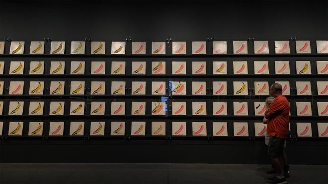 黑色的牆上掛滿 Andy Warhol 的香蕉藝術照片