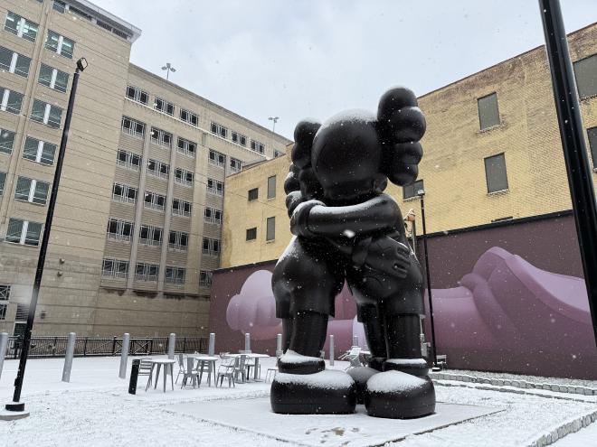 兩隻 KAWS 的雕像在雪中擁抱