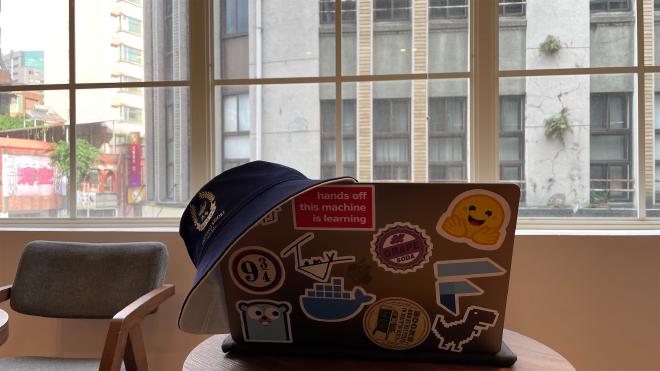 一頂藍色的漁夫帽掛在 MacBook 上